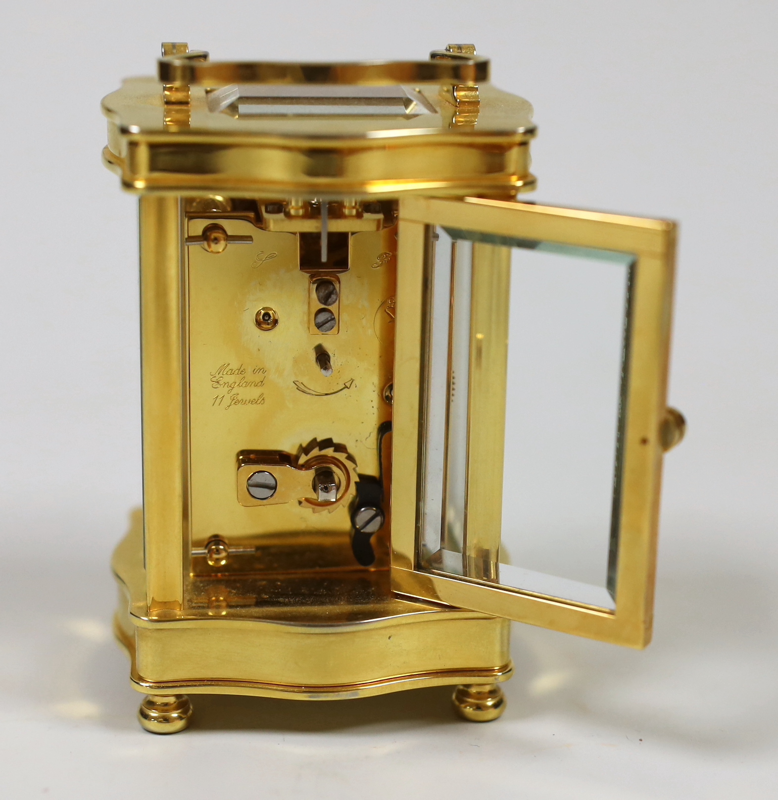 A French miniature brass cased serpentine fronted eight day carriage timepiece by L’Epee, 9cm high